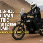 Close-up view of the Royal Enfield Himalayan Electric’s custom aluminum swingarm, tubeless spoked wheels, and protective battery casing on a rocky Ladakh trail.