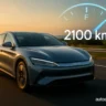 BYD Hybrid Car 2025 driving with 2100km range indicator at sunset on highway – autoakhbar.com