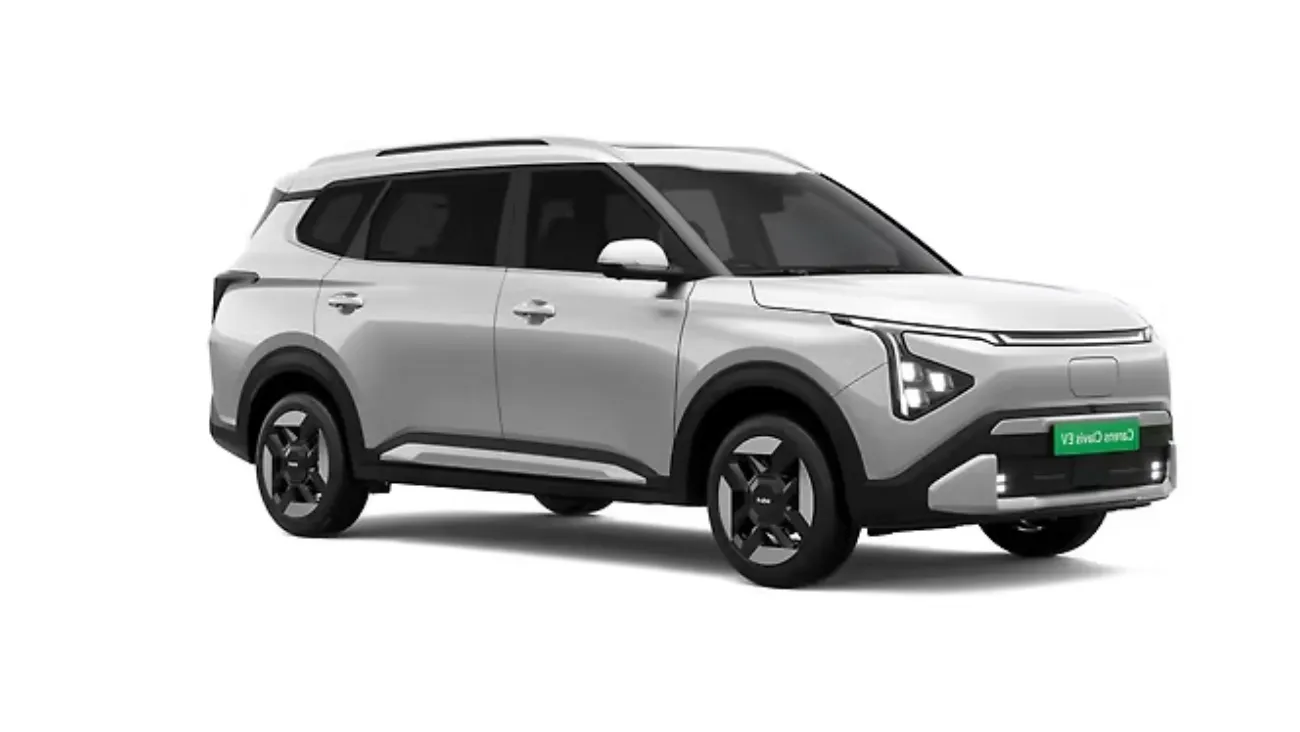 Kia Carens Clavis EV at a charging station in a futuristic city – autoakhbar.com