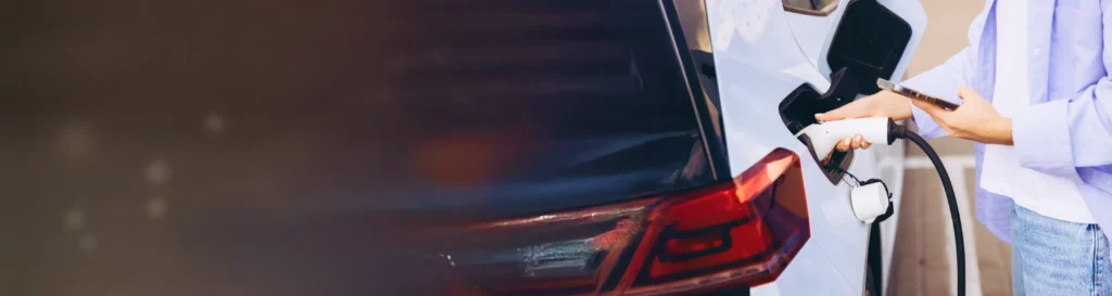 Electric car charging at an EV station during sunset with text "5 Proven Tips to Extend Your EV Battery Life (From Real Experience!)"