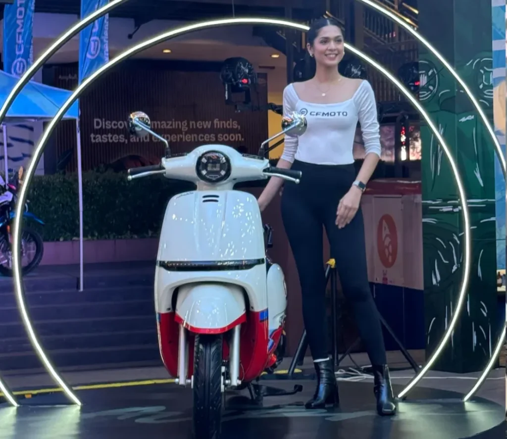 CFMOTO 150 Aura retro scooter displayed at launch event with model showcasing the scooter