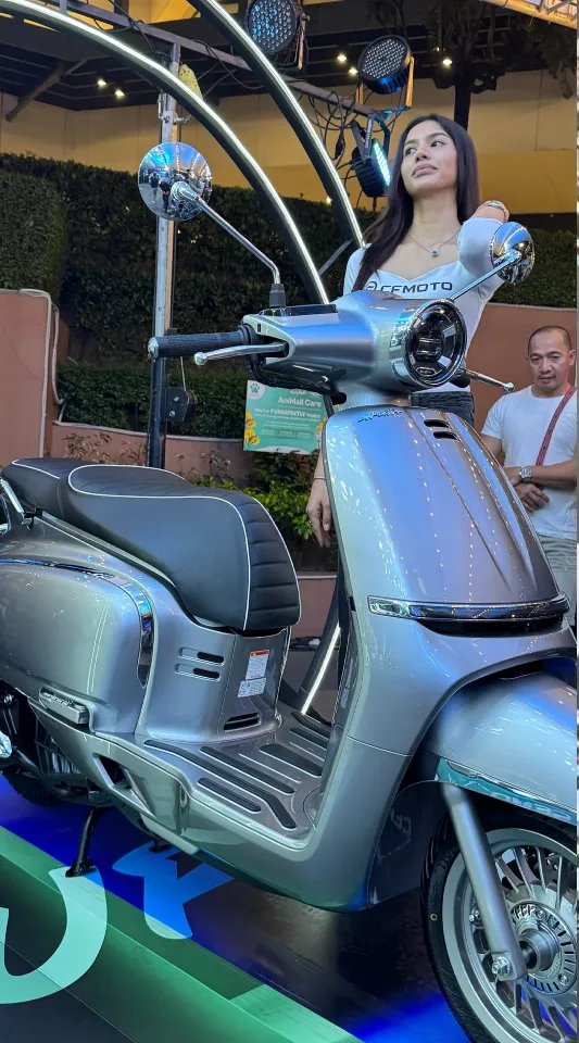 CFMOTO 150 Aura retro scooter displayed at launch event with model showcasing the scooter