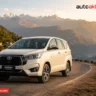 A Toyota Innova Crysta rental car on a scenic mountain road in India 2026