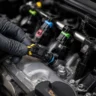 Plug-and-play injector harness connectors being installed on fuel injectors as part of E85 flex fuel kit setup