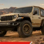 2027 Jeep Wrangler Laredo with tan soft-top and bronze wheels parked on a desert trail