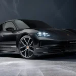2026 Porsche Taycan 4 electric sedan on a city street at dusk, AutoAkhbar branded image