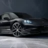 2026 Porsche Taycan 4 electric sedan on a city street at dusk, AutoAkhbar branded image