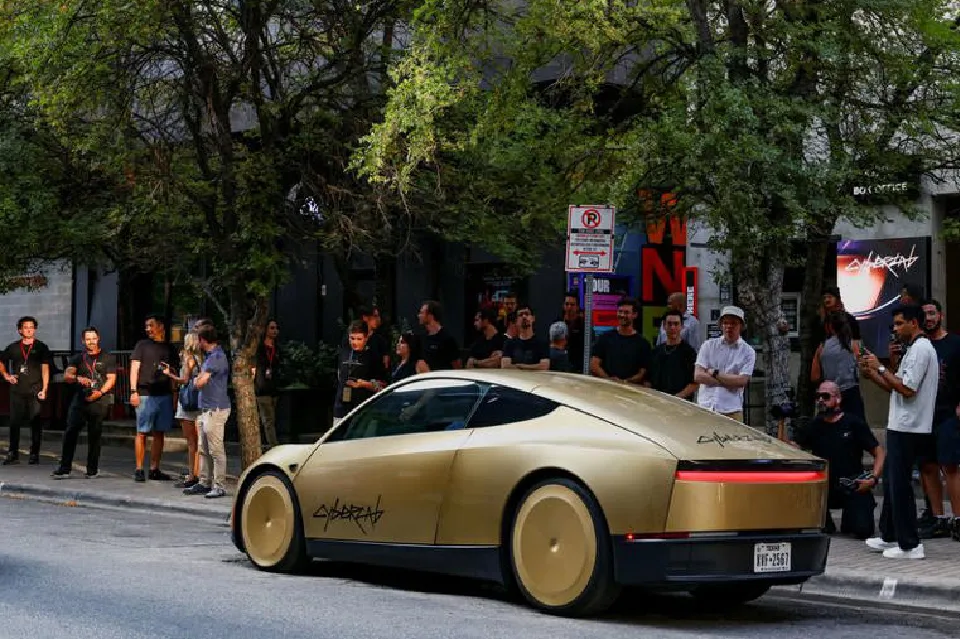 Two-seat autonomous Tesla Cybercab robotaxi without a steering wheel, shown on a city street.