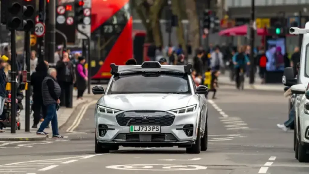 Wayve AI Driver autonomous vehicle navigating busy London streets with pedestrians and traffic
