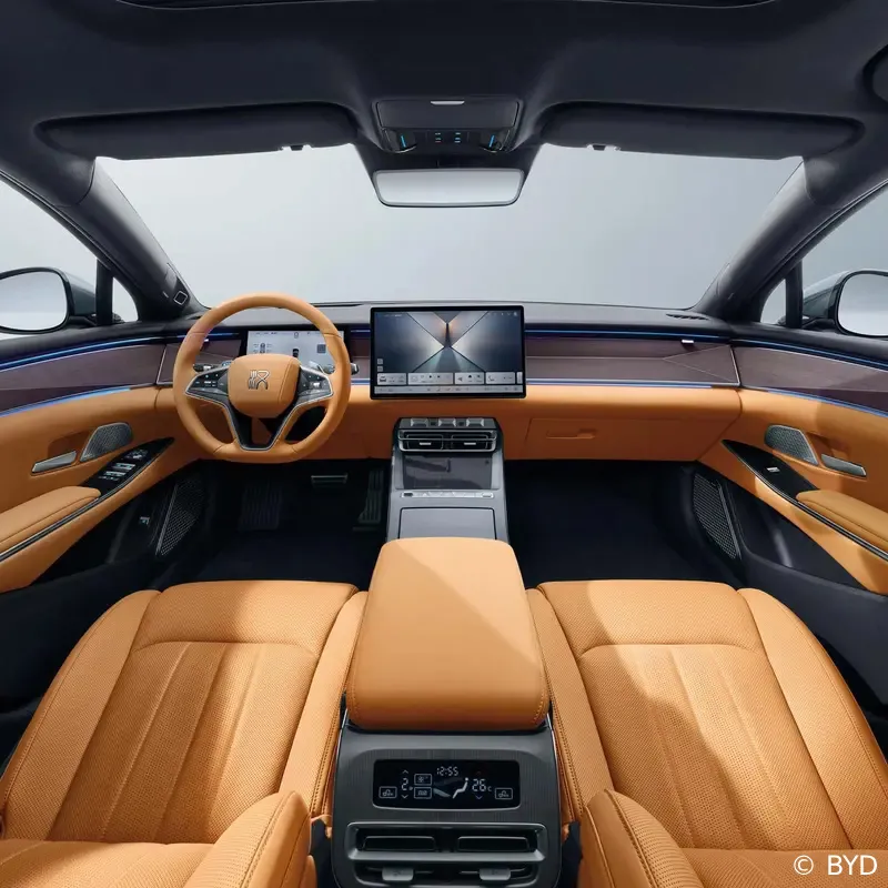 The premium tan leather interior of the BYD Han L electric sedan, highlighting the steering wheel, large central touchscreen display, and luxury dashboard console.