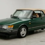 Classic british green 1991 Saab 900 Turbo Convertible car with tan soft top in a studio setup