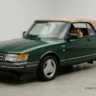 Classic british green 1991 Saab 900 Turbo Convertible car with tan soft top in a studio setup