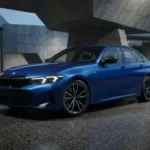 2027 BMW 3 Series sedan front three-quarter profile showing controversial shark nose and aggressive hood design on Autoakhbar.com