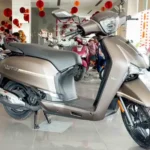 Front three-quarter view of the new Hero Destini 110 Classique Edition scooter in a premium bronze color scheme displayed inside a Hero MotoCorp dealership showroom.