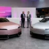 Side by side view of the boxy copper Jaguar Type 00 concept car and the sleek silver four-door Jaguar Type 01 production model displayed in a premium showroom.