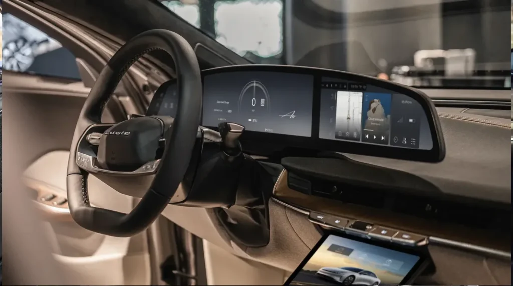 Side profile angle of a Lucid Air luxury EV interior highlighting the leather steering wheel, the sweeping glass cockpit display screen showing media playing, and the lower retractable control screen.