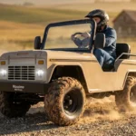 A side-angle dynamic shot of a person wearing a helmet driving a cream-colored Massimo mini truck go-kart while kicking up a trail of dust on a rocky desert path during golden hour.
