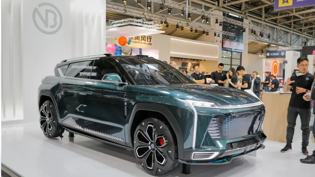 Nobo concept car : A front three-quarter dynamic angle shot of the metallic dark green Nobo iNest 3.0 electric concept vehicle displayed on the exhibition floor, showcasing its massive geometric lower grille, vertical matrix LED daytime running lights, and prominent brand logo.