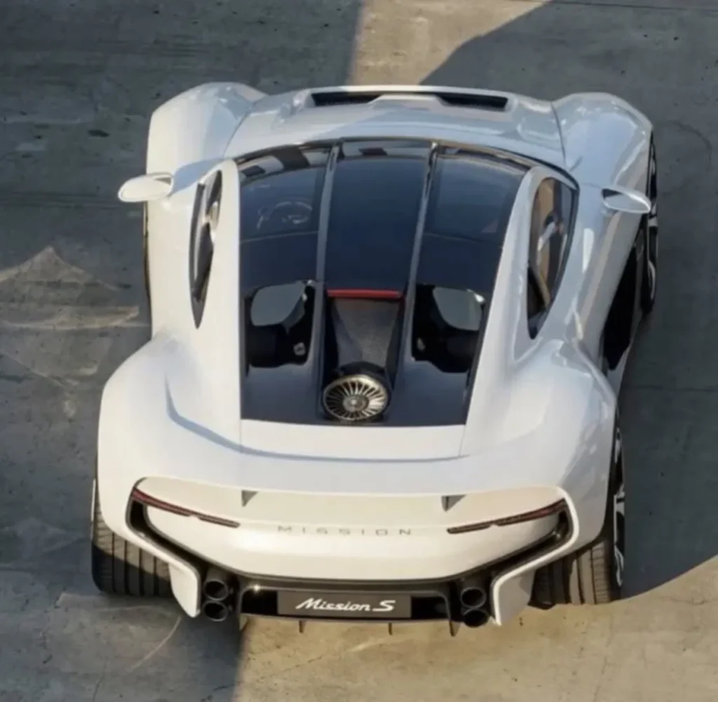A high-angle overhead studio top view of the dark stealth-finish Porsche Mission S concept hypercar, highlighting its sweeping glass canopy, wide track body styling, and rear engine cooling bay vents with red and white corner smoke elements.